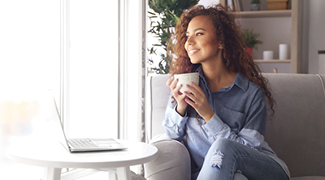woman with a coffee and at her lap top