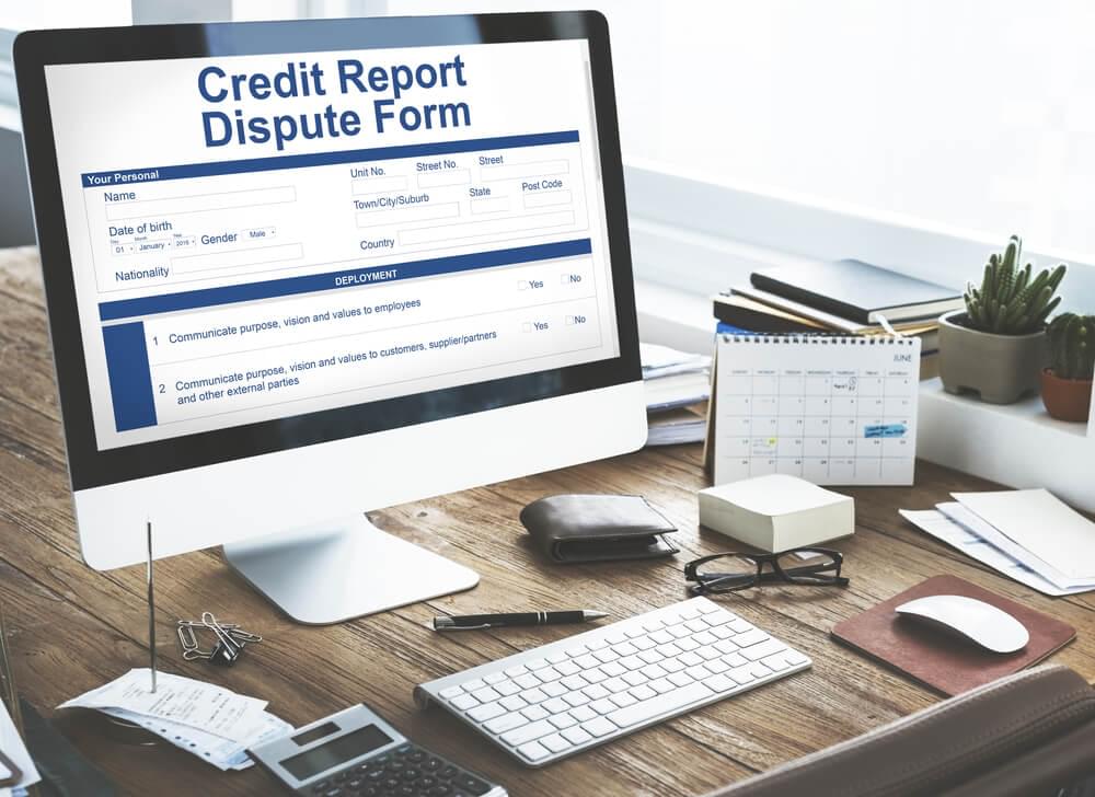 Image of Credit Report Dispute Form on a computer screen that is on a desk.